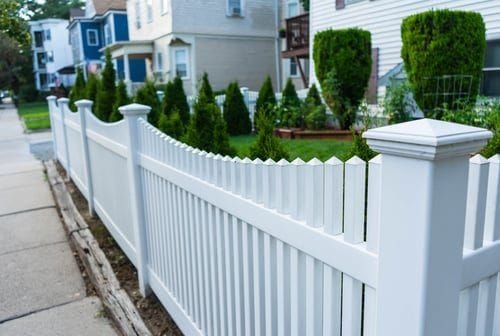 New white privacy fence installed along a landscaped property line in Salinas, California